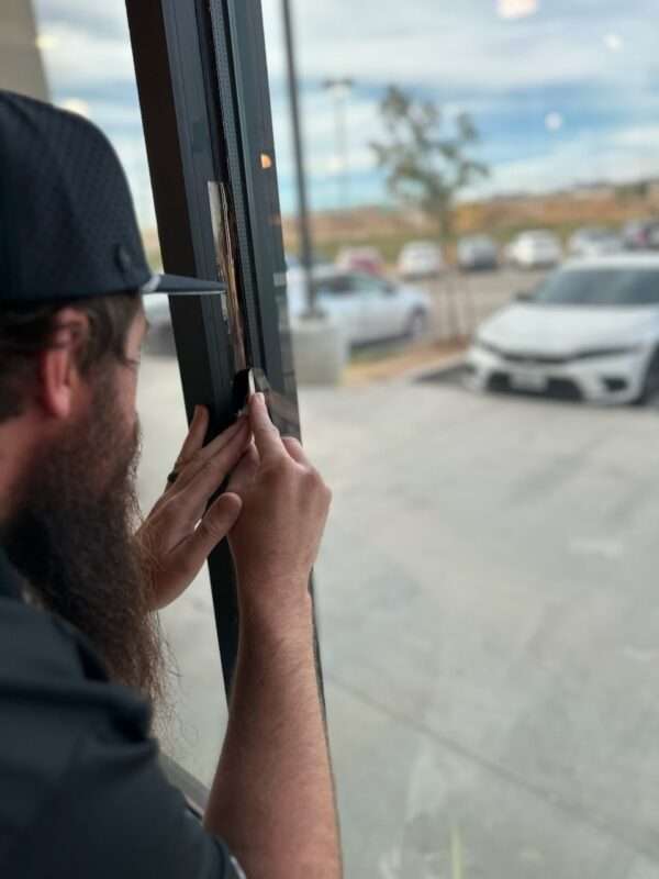 window tint being cut by installer shown here.